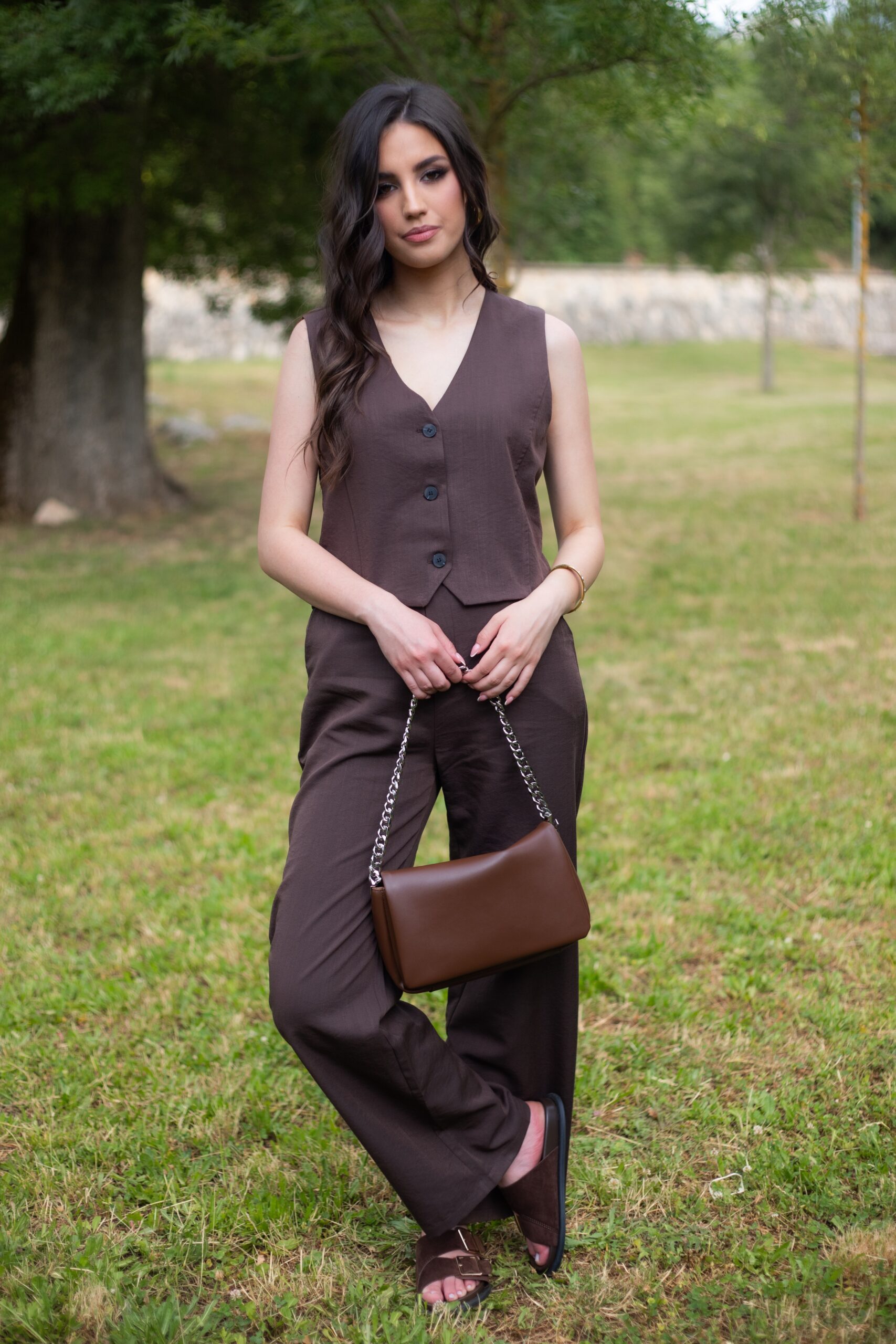 Model nosi smeđi komplet Mocha Chic koji se sastoji od strukiranog prsluka i širokih hlača visokog struka.