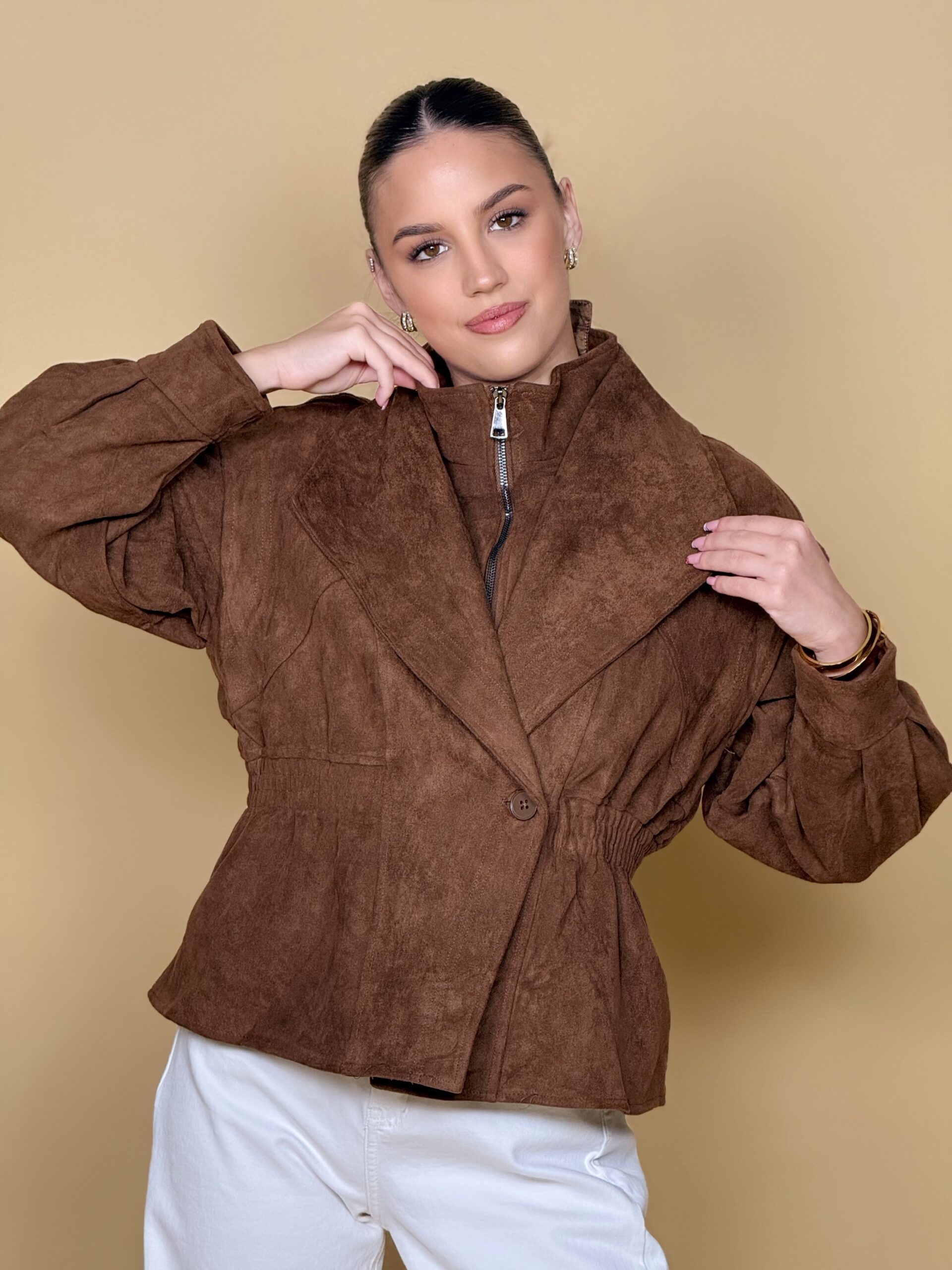 Model nosi žensku smeđu jaknu Cocoa Crown s efektom brušene kože i širokim reverima.