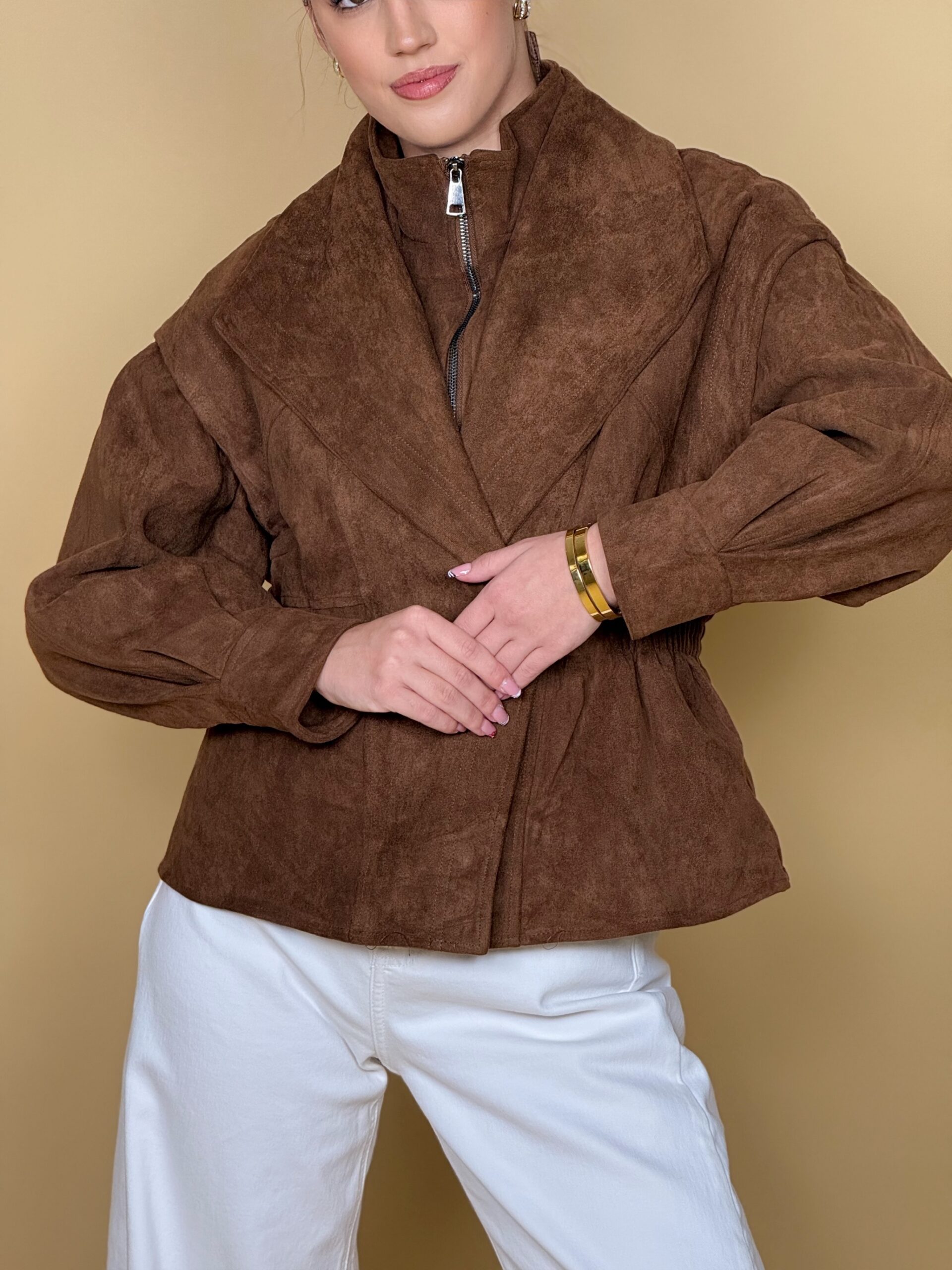 Model nosi žensku smeđu jaknu Cocoa Crown s efektom brušene kože i širokim reverima.