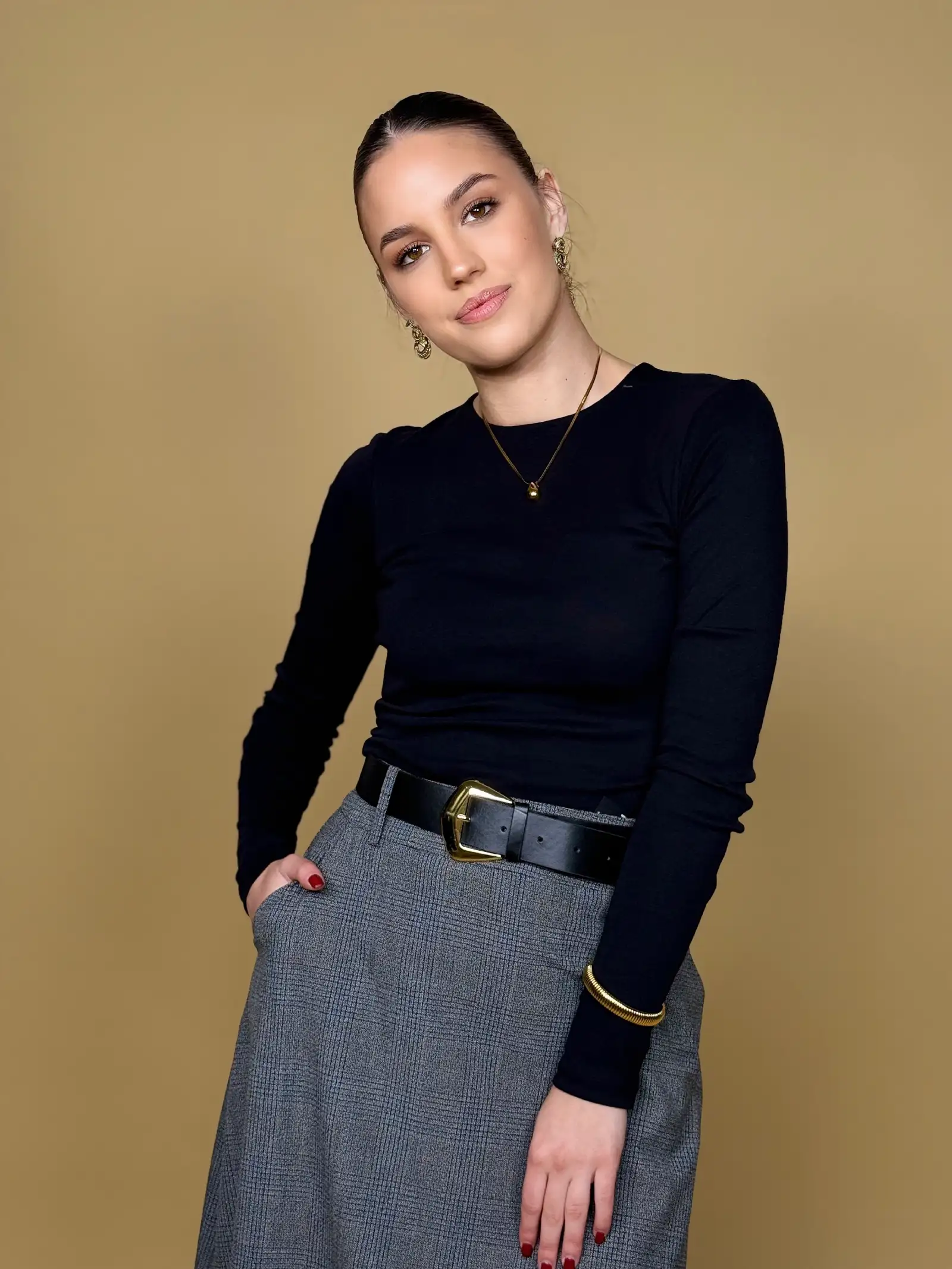 Model nosi žensku crnu majicu Eliza dugih rukava i okruglog izreza.