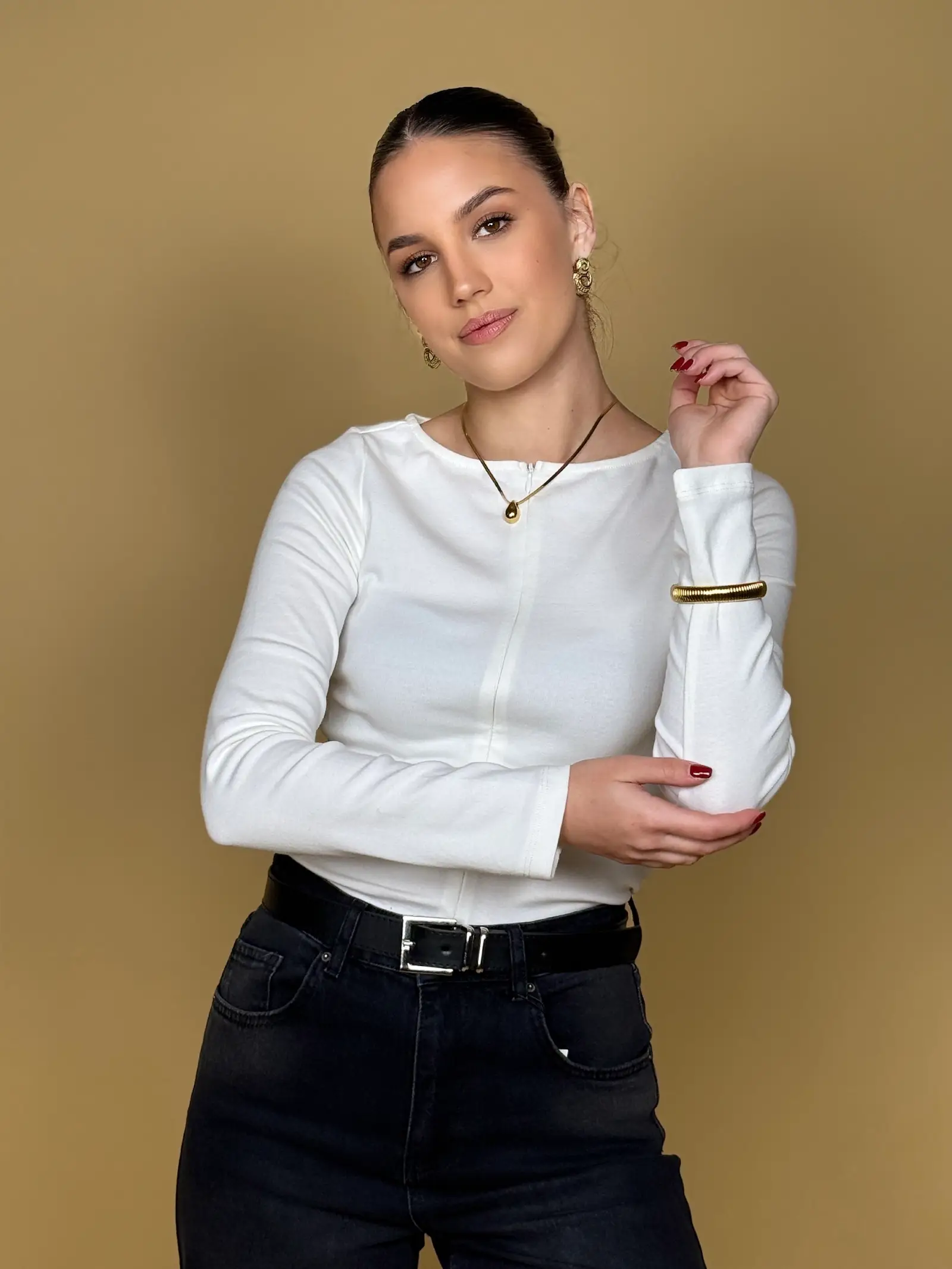 Model nosi žensku bijelu majicu Alessia dugih rukava s patentnim zatvaračem sprijeda.