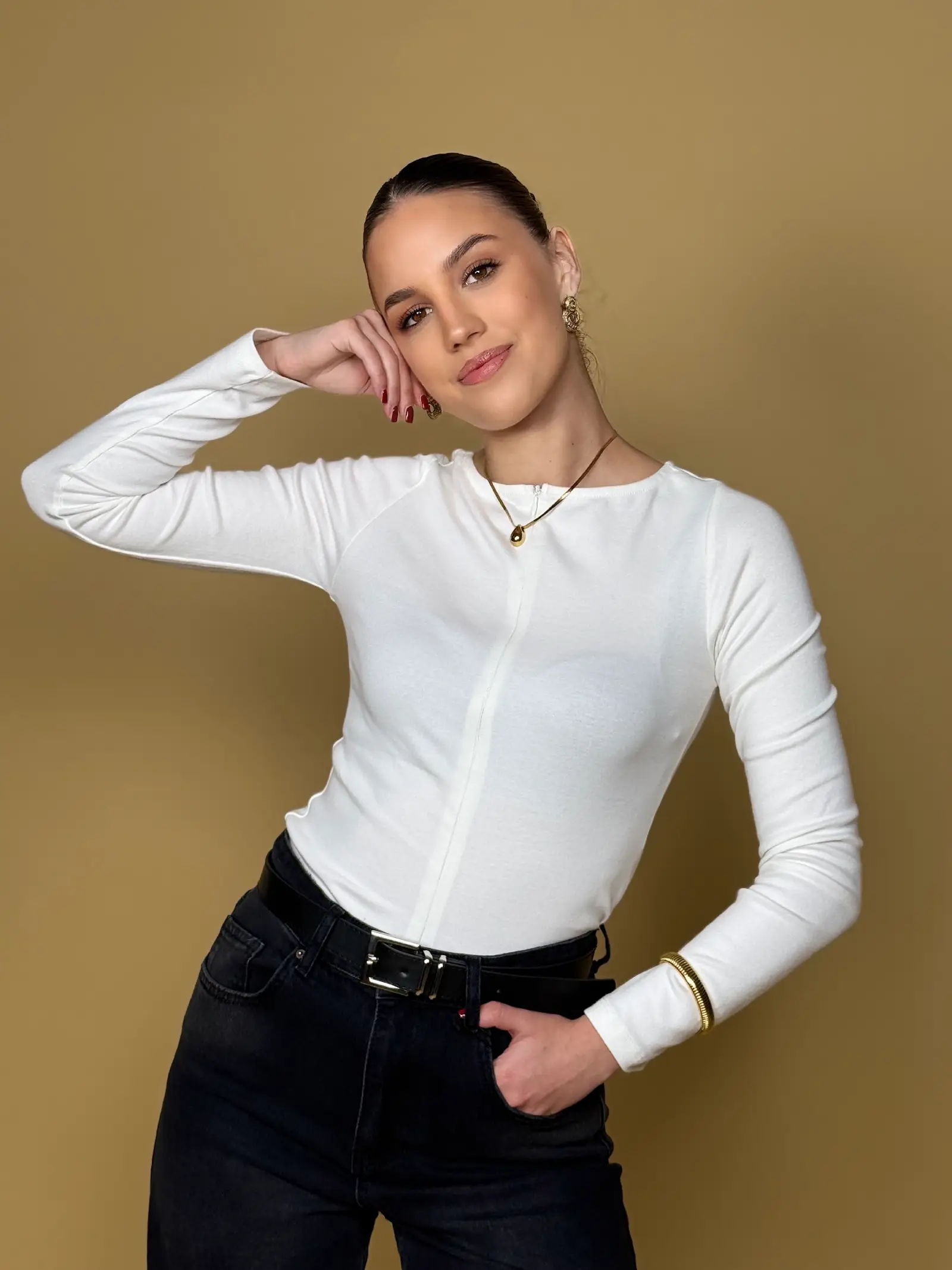 Model nosi žensku bijelu majicu Alessia dugih rukava s patentnim zatvaračem sprijeda.