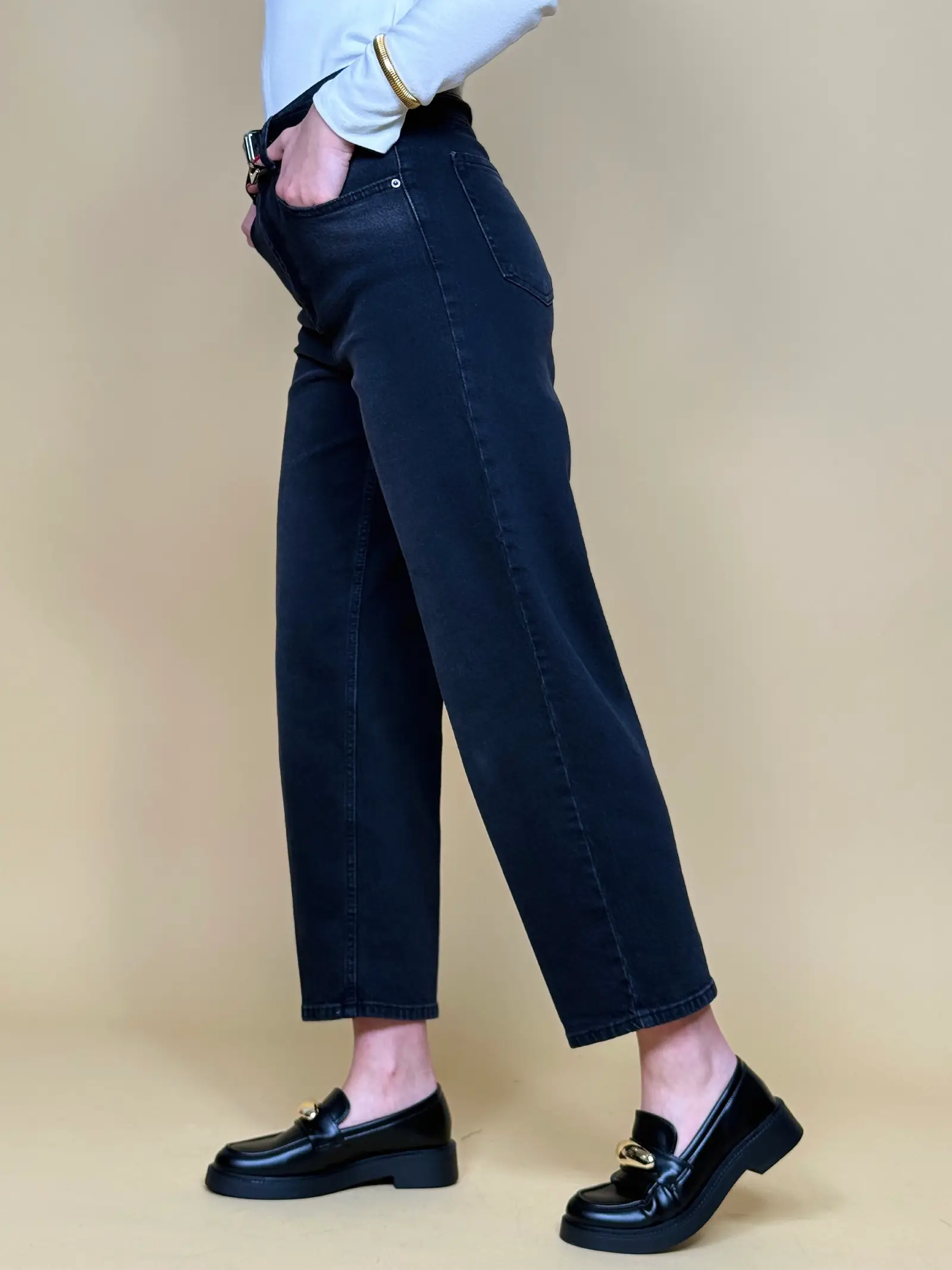 Model nosi ženske sive traperice Monroe visokog struka sa suženim nogavicama i crnim remenom.
