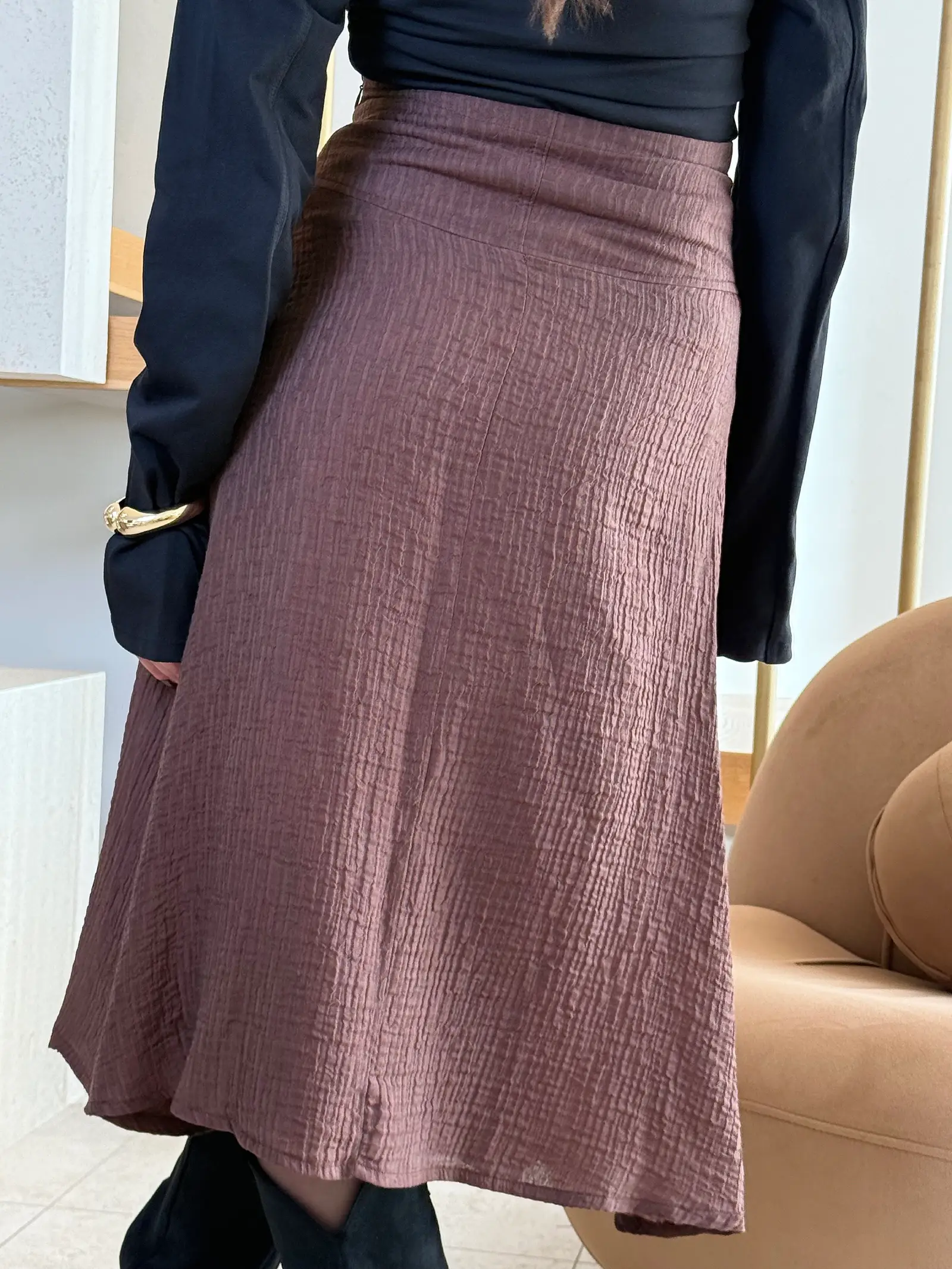 Model nosi žensku smeđu suknju Odette visokog struka, duge i blago proširene siluete.